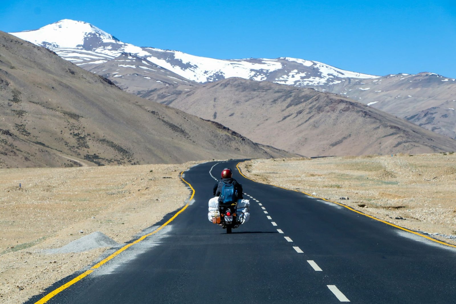 A traveller riding along a dramatic mountain road in Ladakh, India
